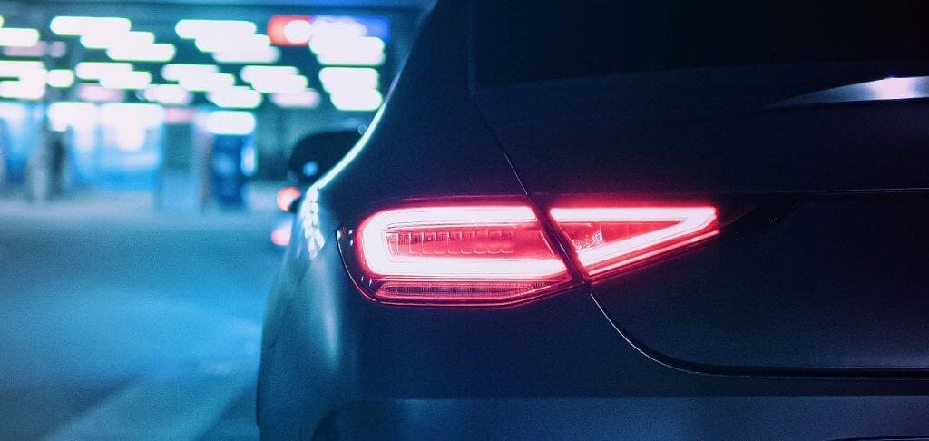 A brightly coloured image in blue and pink hues of the back of a high end vehicle used as the hero image for the Aquasonic carwash brand identity - created by Crux Design Agency UK