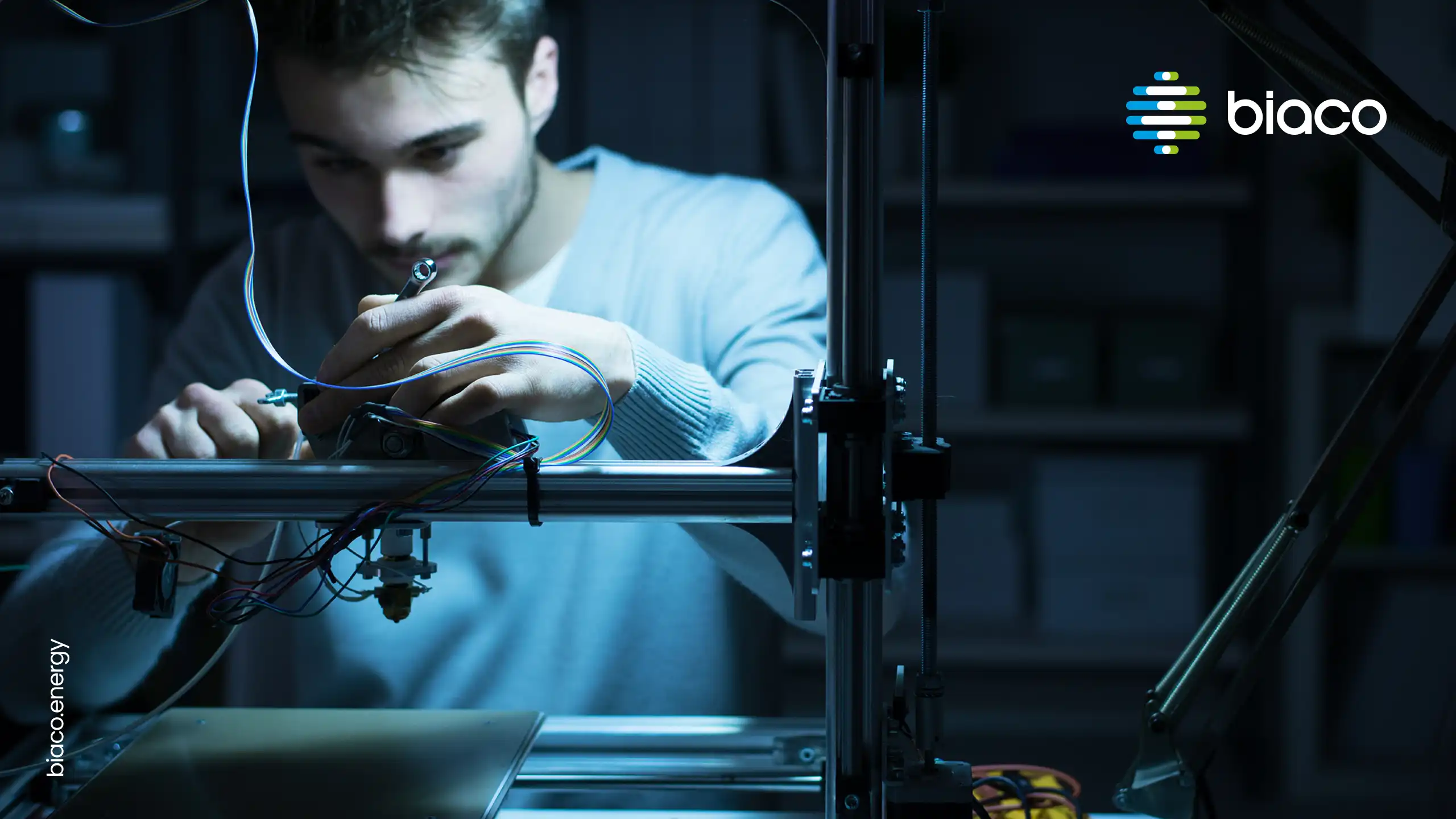 Engineer assembling equipment under focused lighting with Biaco logo overlay.