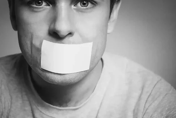 Person with tape over their mouth, symbolising loss of voice and originality in content plagiarism